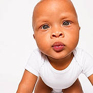 Braylen is registered to the contest to win money with this photo: baby, child, crawling, white_background, onesie, curious, face, portrait, infant, closeup, cute, skin, head, eyes, expression, person, studio, young, front_view, indoor