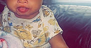 Kamiya is registered to the contest to win money with this photo: baby, child, infant, sitting, couch, blanket, portrait, face, smiling, tongue_out, blue_eyes, curly_hair, onesie, clothing, indoor, window, blinds, home, close_up, happy