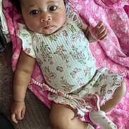 Kamiya is registered to the contest to win money with this photo: baby, infant, child, portrait, lying_down, blanket, pink_blanket, floral_outfit, dress, socks, pacifier, baby_toy, face, eyes, curly_hair, smiling, indoor, closeup, soft_fabric, adorable