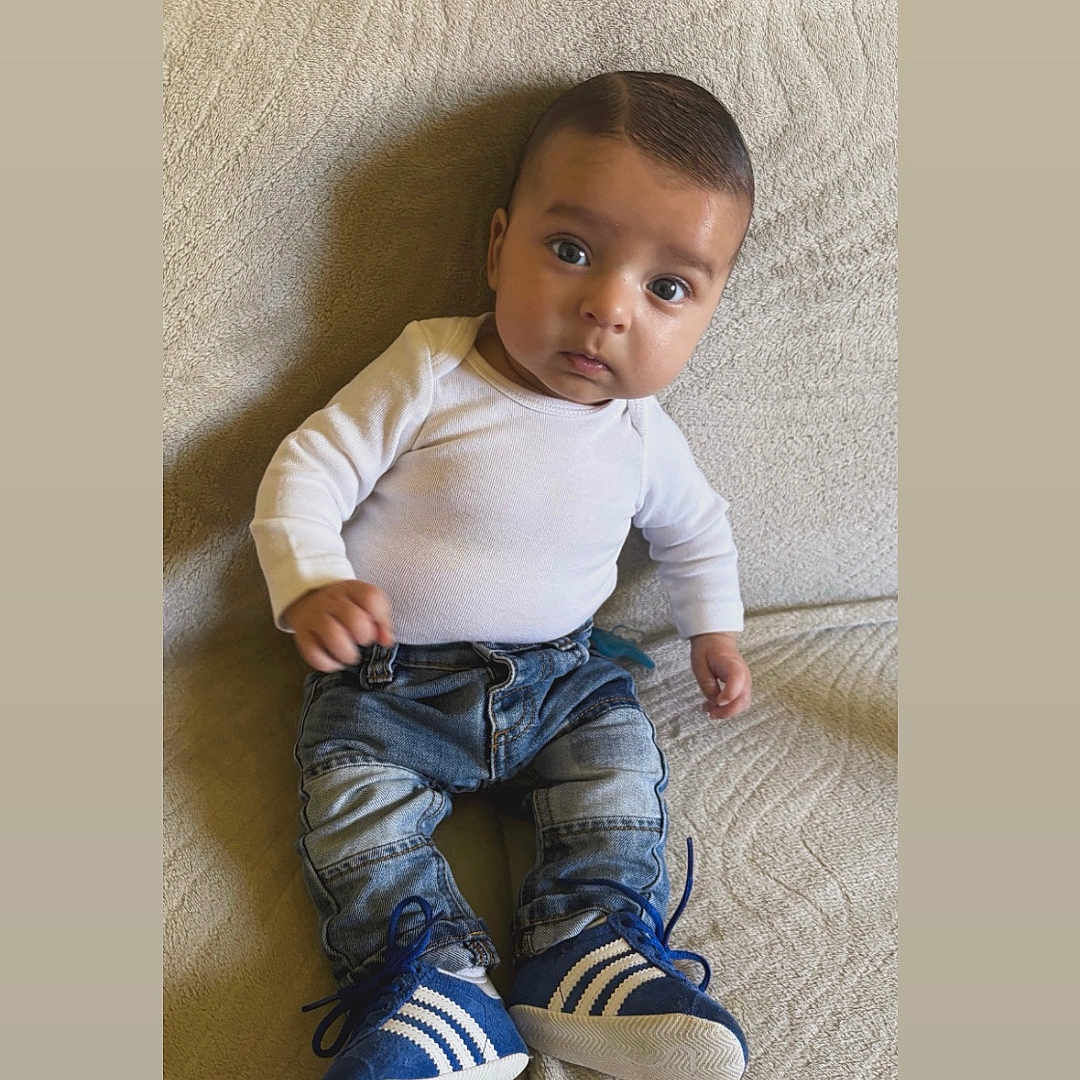Zeyden participe au concours pour gagner de l'argent avec cette photo : baby, baby_fashion, blue_shoes, casual_clothing, child, comfortable, couch, cute, denim, indoor, infant, jeans, looking_at_camera, portrait, seated, small_shoes, sneakers, textured_fabric, white_shirt, young_child