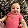 Aylani is registered to the contest to win money with this photo: baby, baby_girl, blanket, cheerful, child, clothing, cushion, cute, face, happy, indoor, infant, patterned_pillow, person, pink_onesie, portrait, sitting, smile, soft_fabric, young_child