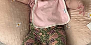 Aylani is registered to the contest to win money with this photo: adorable, baby, bed, bib, child, comfortable, cushion, cute, embroidery, floral_pants, headband, indoor, infant, pacifier, person, pink, seated, smiling_eyes, socks, soft_texture