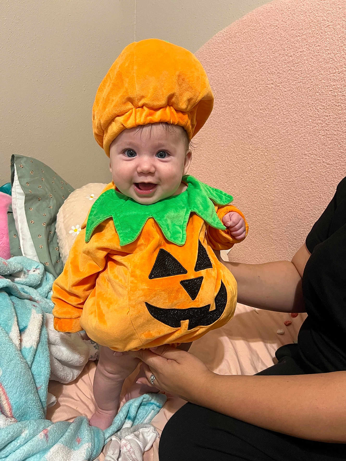 Aylani is registered to the contest to win money with this photo: baby, bed, blanket, celebration, child, costume, cozy, cute, festive, green, halloween, happy, holding, indoor, infant, orange, person, pillow, pumpkin_costume, smile