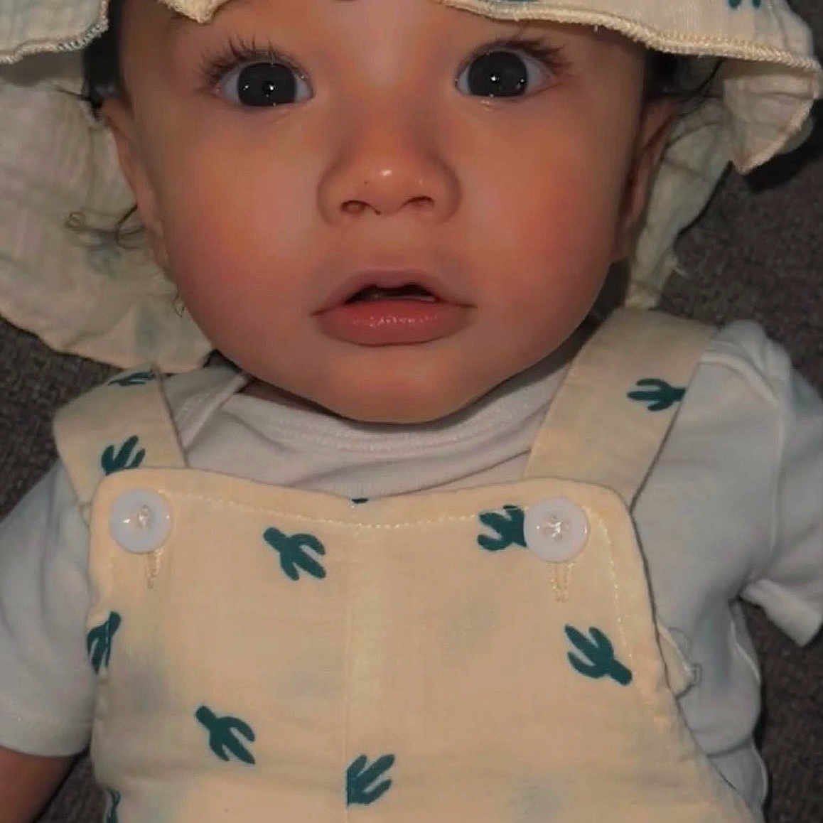 Legend is registered to the contest to win money with this photo: baby, bonnet, clothing, coat, face, hat, head, hood, person, photography, portrait, skin, sleeve, spitting, sunhat, tattoo