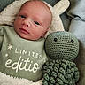 baby, newborn, infant, blanket, green_onesie, limited_edition_text, knitted_toy, octopus_toy, soft_lighting, closeup, portrait, cute, cozy, sleeping_baby, child, face, head, fabric, plush, resting