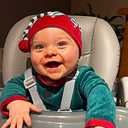 Malo participe au concours pour gagner de l'argent avec cette photo : baby, infant, high_chair, smile, elf_hat, holiday_outfit, green_clothing, red_hat, blue_eyes, rosy_cheeks, hands, tray, straps, seat, cute, portrait, indoor, happy, child, person