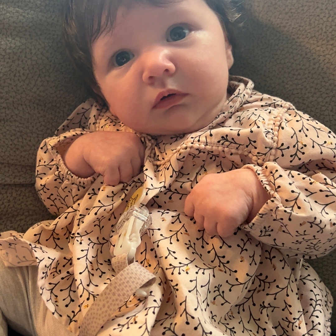 Maëlyn participe au concours pour gagner de l'argent avec cette photo : baby, child, clothing, couch, curious, cute, eyes, fabric, face, fingers, hand, indoor, infant, pacifier, patterned_dress, portrait, sitting, soft_lighting, texture, young