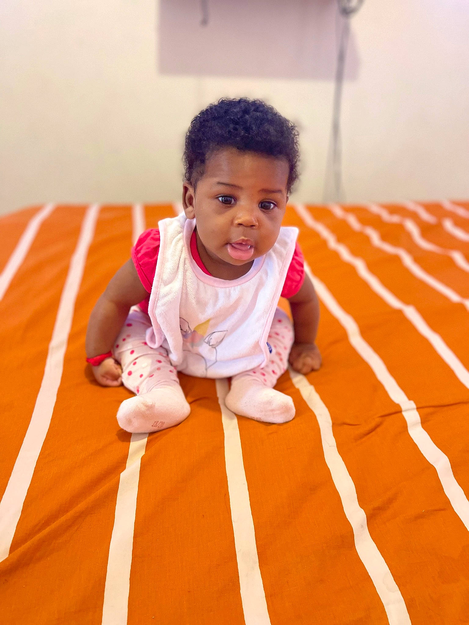 Naësha a rejoint le concours — aidez-le/la à gagner de superbes lots ! baby, baby_toddler_clothing, child, comfort, crawling, elbow, finger, floor, flooring, fun, hand, happy, hardwood, linens, orange, person, sitting, skin, sleeve, thumb