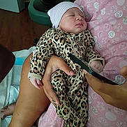Leilani joined the competition — help win amazing prizes! newborn, baby, sleeping, infant, portrait, leopard_print, onesie, beanie, hat, blanket, pink, adult_hand, indoor, nursery, cozy, sitting, cradle, phone, close_up, peaceful