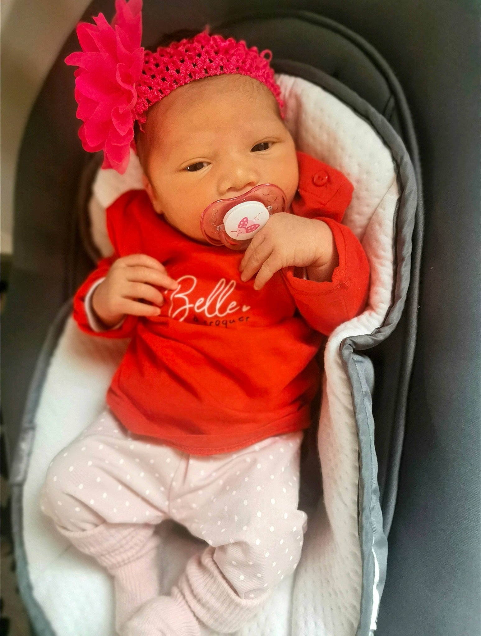 Tessa participe au concours pour gagner de l'argent avec cette photo : baby, baby_toddler_clothing, cap, cheek, chin, comfort, hand, hat, head, headwear, human_body, lip, mouth, orange, organ, outerwear, person, pink, product, sleeve