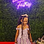Milanie is registered to the contest to win money with this photo: child, girl, princess, dress, lavender, tiara, braids, red_carpet, smile, portrait, green_background, neon_sign, event, happy, fashion, young, celebration, cute, standing, indoor