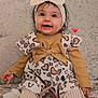 baby, child, smiling, headband, bow, dress, hearts, toy, teether, couch, knitted_tights, happy, cute, indoors, portrait, infant, sitting, clothing, warm_colors, head