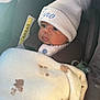 baby, child, car_seat, blanket, hat, pom_pom, pacifier, face, clothing, knit, indoor, seatbelt, cute, infant, warm, comfort, portrait, young_child, expression, car