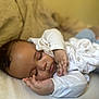 baby, sleeping, couch, blanket, infant, child, face, peaceful, rest, soft, cozy, indoors, clothing, person, portrait, hand, curly_hair, comfort, relax, home