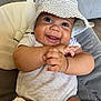 baby, smiling, hat, clothing, infant, cute, happy, hands, face, portrait, child, indoor, seat, cushion, person, skin, eyes, toddler, closeup, expression