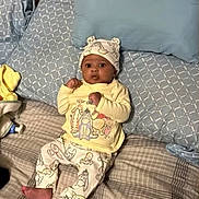Poem joined the competition — help win amazing prizes! baby, child, bed, pillow, blanket, hat, clothing, infant, cute, pattern, cartoon, sleepwear, footwearless, indoors, person, lying_down, expression, young, soft_furnishing, cozy