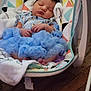 Storm is registered to the contest to win money with this photo: baby, sleeping, blue_dress, baby_rocker, lion_toy, blanket, infant, cute, peaceful, wooden_floor, indoors, child, toddler, clothing, resting, furniture, soft, patterned, colorful, hands