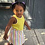 casual, child, concrete, cute, daytime, fashion, hair_bows, outdoor, person, purple_bows, shadow, sidewalk, sneakers, striped_skirt, sunlight, toddler, urban, walking, yellow_top, young_girl