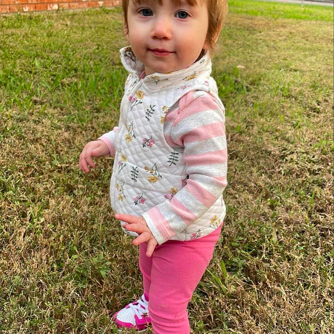 Athena joined the competition — help win amazing prizes! backyard, child, clothing, face, female, footwear, girl, grass, head, lawn, nature, outdoors, pants, person, photography, plant, portrait, shoe, standing, yard