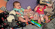 Kamden is registered to the contest to win money with this photo: baby, bedding, blanket, bottle, child, clothing, colorful, cute, face, feeding, hat, indoors, infant, person, pillow, playful, plush_toy, sitting, smiling, toy