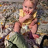 Kimberlynn is registered to the contest to win money with this photo: baby, child, infant, bed, blanket, floral_pattern, diaper, yellow_clothing, sitting, playful, face, hand, foot, food_container, indoor, curly_hair, expression, cute, person, soft_lighting