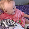 Kimberlynn joined the competition — help win amazing prizes! baby, bed, bedding, child, clothing, cute, face, happy, head, indoor, infant, person, pink_shirt, playful, purple_blanket, sitting, smiling, striped_blanket, toddler, young
