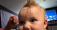 Kimberlynn is registered to the contest to win money with this photo: baby, child, face, hair, indoor, hand, person, television, screen, room, curious, expression, wild_hair, skin, portrait, playful, light, furniture, background, closeup