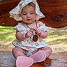 baby, bench, child, clothing, curious, cute, hat, infant, nature, necklace, outdoor, pink_shoes, portrait, sitting, strawberry_pattern, summer, sun_hat, sunlight, wood, wooden_pendant