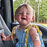 blue_dress, car_seat, child, cute, daylight, forest, hand, happy, infant, lemon_pattern, nature, outdoor, person, pony_tail, portrait, seat, smiling, toddler, trees, window
