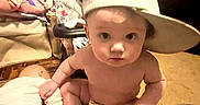 Kimberlynn is registered to the contest to win money with this photo: baby, cap, carpet, child, clutter, curious, doll, expression, face, floor, furniture, hat, home, indoors, looking, naked, person, sitting, small, toy