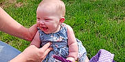 Sapphire is registered to the contest to win money with this photo: baby, child, grass, smile, laughing, outdoor, basket, purple, polka_dot, dress, floral, person, hand, tattoo, greenery, garden, brick_wall, toy, happy, sitting