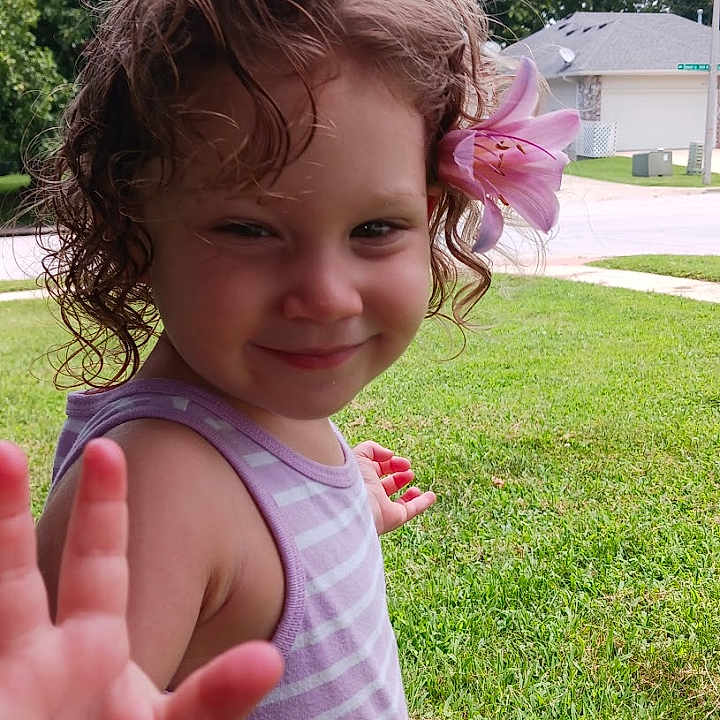 Ana'Leigh Rose joined the competition — help win amazing prizes! child, curly_hair, cute, daylight, flower, girl, grass, happy, lily, nature, outdoor, person, portrait, purple_stripes, residential_area, smiling, summer, tank_top, trees, waving_hand