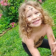 Ana'Leigh Rose is registered to the contest to win money with this photo: child, mud, smile, curly_hair, outdoor, garden, flowers, greenery, grass, play, happy, nature, face_paint, bare_chest, window, brick_wall, plant, spring, fun, daylight