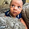baby, infant, blanket, fur, couch, curious, face, head, indoors, person, portrait, skin, expression, blue_clothing, young_child, soft_texture, resting, cozy, closeup, newborn