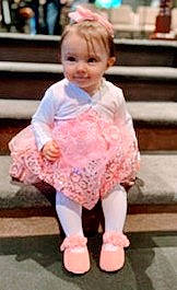 Journey is registered to the contest to win money with this photo: baby, baby_toddler_clothing, child, costume, embellishment, event, fashion_accessory, flooring, happy, joy, magenta, pattern, peach, person, photograph, pink, ruffle, sitting, sleeve, smile