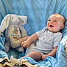 baby, infant, smiling, blue_blanket, plush_toy, stuffed_bunny, easter, soft_texture, cute, happy, child, indoor, portrait, rosy_cheeks, buttoned_onesie, sitting, cozy, light, toy, celebration