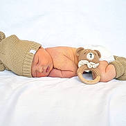 Bennett is registered to the contest to win money with this photo: newborn, baby, sleeping, knitted_hat, bear_ears, booties, crocheted_toy, bear_rattle, white_blanket, soft_texture, cute, infant, peaceful, resting, portrait, child, cozy, warm, adorable, lying_down