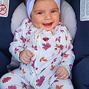Melissa is registered to the contest to win money with this photo: baby, child, infant, onesie, headband, bow, car_seat, smiling, happy, cute, clothing, pattern, leaf, autumn, seatbelt, indoor, portrait, baby_girl, comfort, closeup
