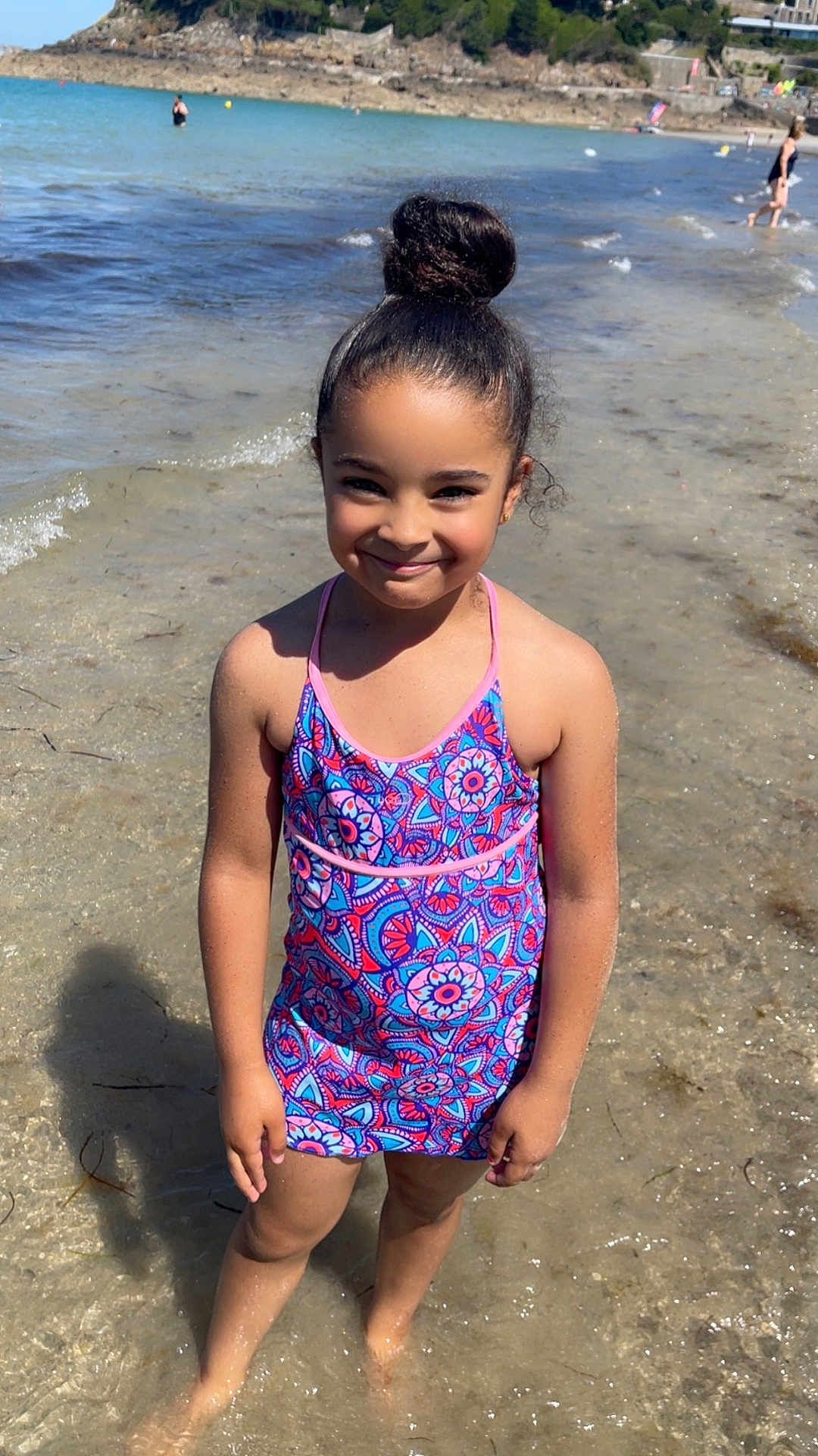 Royda participe au concours pour gagner de l'argent avec cette photo : child, girl, swimsuit, beach, water, smile, sunny, hair_bun, sand, waves, outdoor, summer, vacation, playful, happy, shore, nature, person, feet_in_water, holiday