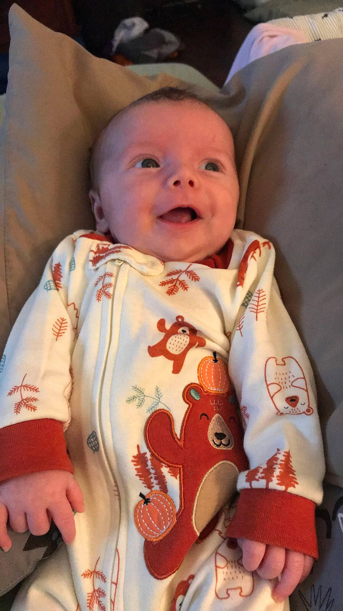 Benji is registered to the contest to win money with this photo: arm, baby, baby_products, baby_toddler_clothing, bib, cheek, child, comfort, dress, eye, facial_expression, finger, happy, nose, peach, person, sitting, skin, sleeve, smile