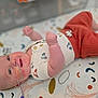 baby, infant, smile, lying_down, nasal_tube, medical_tape, cute_outfit, patterned_blanket, raised_fists, close_up, head, cheek, skin, person, child, indoors, colorful, soft_lighting, happy, small_arms