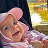 baby, child, pink_hat, pink_jacket, smiling, happy, outdoor, pond, water, flamingos, nature, sunlight, infant, face, portrait, hands, stroller, closeup, daylight, cute