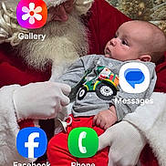 Legend is registered to the contest to win money with this photo: app_icons, baby, background_backdrop, beard, child, christmas, costume, festive, gloves, holiday, indoor, infant, looking_up, pacifier, phone_screenshot, portrait, red_clothing, santa_claus, sitting, white_fur