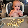 Legand is registered to the contest to win money with this photo: baby, high_chair, banana, food, kitchen, child, eating, tray, cute, infant, person, cabinet, window, trash_can, curious, indoor, furniture, young_child, snack, nibble