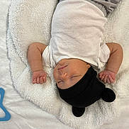 Matteo joined the competition — help win amazing prizes! baby, sleeping, infant, white_onesie, black_hat, bear_ears, blanket, fluffy, soft_texture, peaceful, cute, hands, fist, cozy, serene, child, portrait, indoor, resting, newborn