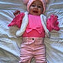 baby, child, smiling, pink_hat, pom_poms, pink_clothing, bow, white_vest, pink_pants, boots, cozy, blanket, lying_down, happy, cute, infant, warm_clothing, fashion, portrait, indoors