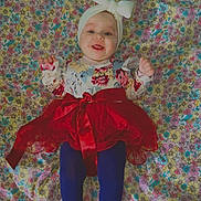 Yuhme a rejoint le concours — aidez-le/la à gagner de superbes lots ! baby, child, tutu, red_skirt, headband, bow, floral_pattern, blanket, colorful, face_filter, heart_shapes, blue_tights, smiling, lying_down, indoors, cute, happy, infant, patterned_clothing, portrait