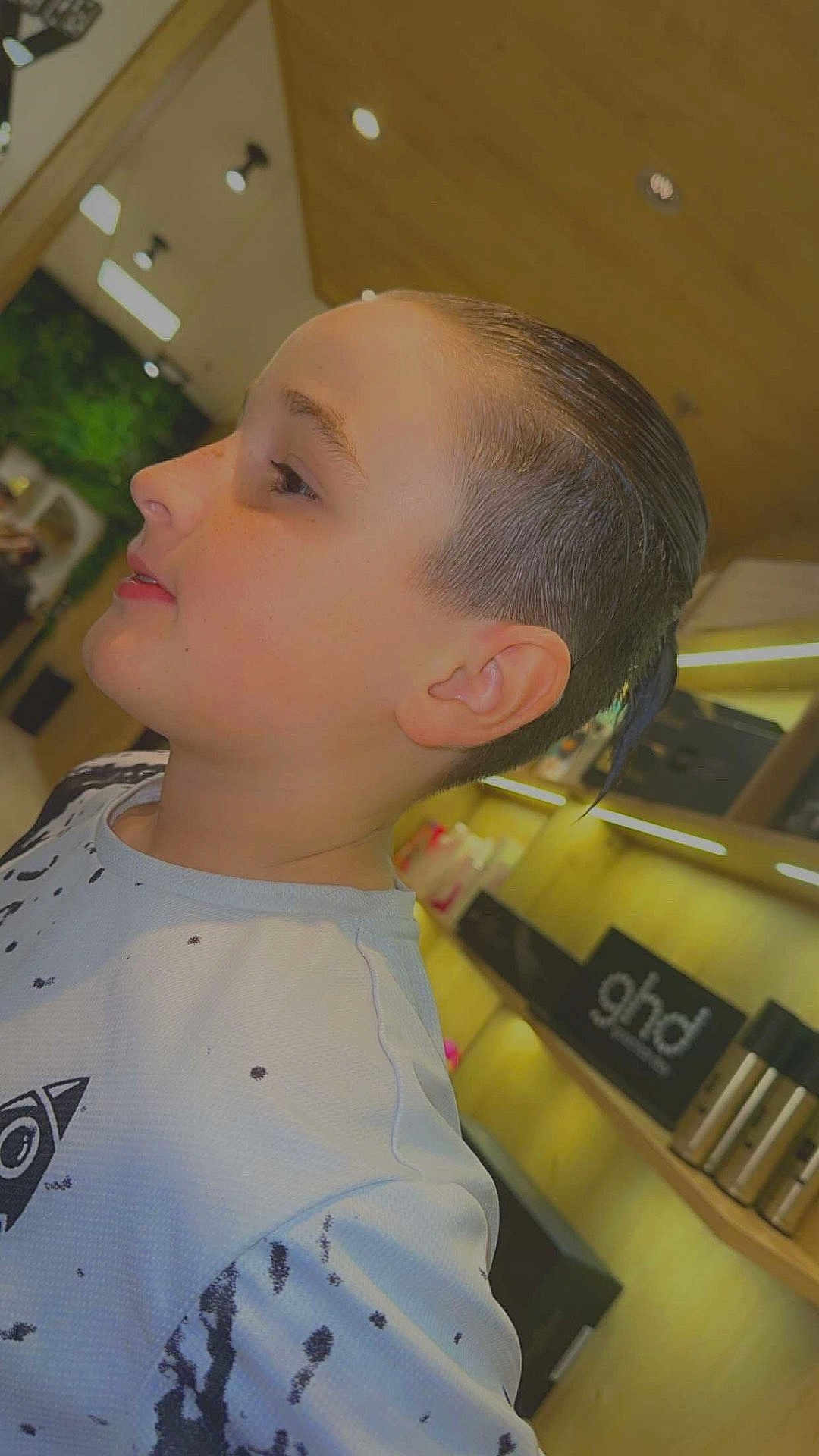 Thao participe au concours pour gagner de l'argent avec cette photo : child, profile, hairstyle, indoor, modern, shelf, hair_products, signage, white_shirt, black_splatter, person, face, ear, lighting, hair, young, casual_clothing, salon, portrait, side_view