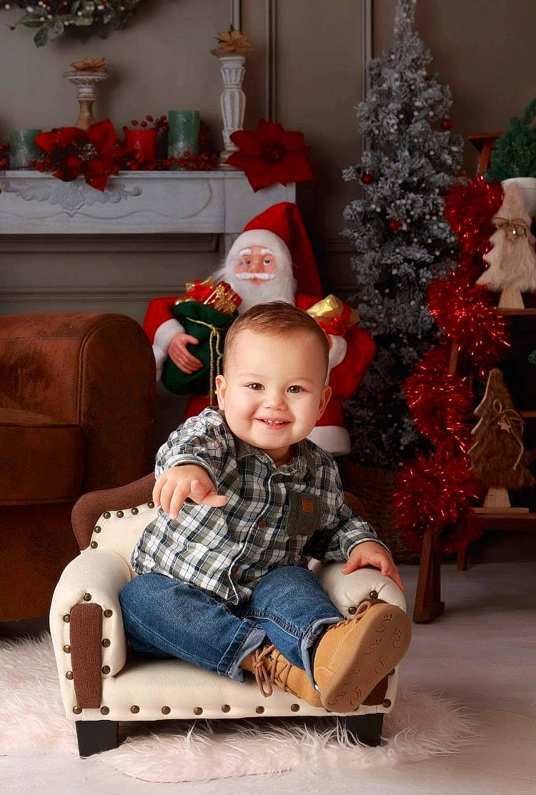 Raphaël participe au concours pour gagner de l'argent avec cette photo : baby_toddler_clothing, child, christmas, christmas_decoration, christmas_ornament, christmas_tree, dress, event, eye, happy, holiday, holiday_ornament, houseplant, human_body, joy, lap, ornament, person, plant, sitting