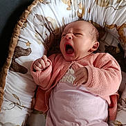 Kiarah participe au concours pour gagner de l'argent avec cette photo : baby, infant, yawning, pink_clothing, cardigan, cozy, cushion, animal_print, soft, nest, newborn, cute, sleepy, indoor, portrait, child, human, furniture, relaxing, resting